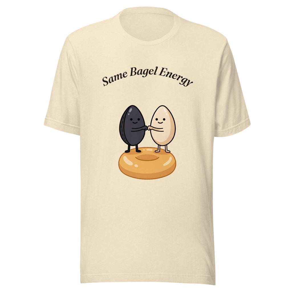 Same Bagel Energy t-shirt with a black sesame seed and a tan sesame seed fist-bumping on a bagel, cream